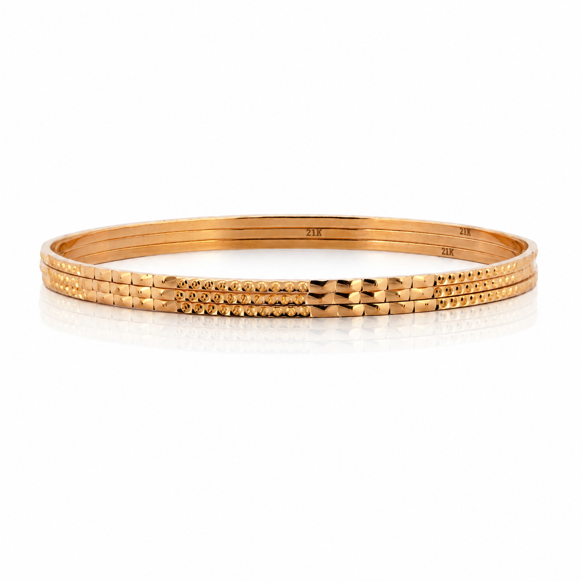 Three 21K yellow gold patterned bangles showing 21K hallmarks