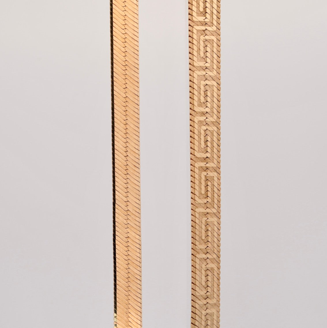 Gemmas Jewelry Edit The Aureo Dual Chain featuring a reversible gold herringbone and Greek key pattern design.