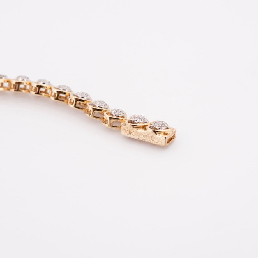 Gemmas Jewelry Edit 10k yellow gold tennis bracelet with heart-shaped links adorned with diamond clusters.