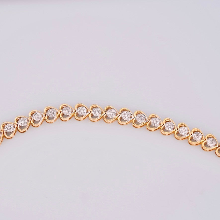 Gemmas Jewelry Edit 10k yellow gold tennis bracelet with heart-shaped links adorned with natural diamonds.