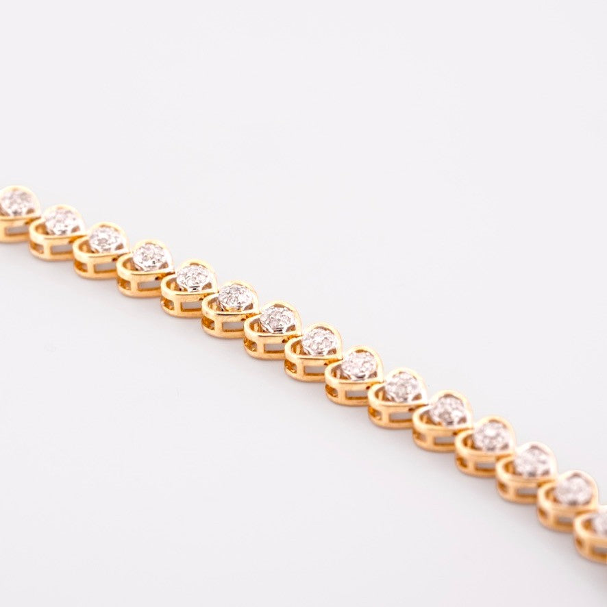 Gemmas Jewelry Edit 10k yellow gold tennis bracelet with heart-shaped links adorned with diamond clusters.